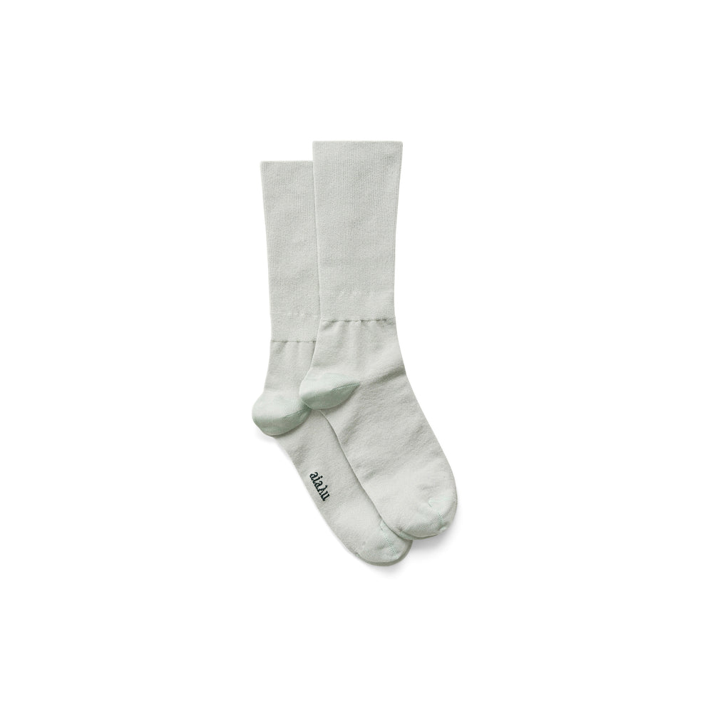 A pair of light green Silk Socks by Aiayu with reinforced toe and heel, superior breathability, and "Aiayu" text on the side of one sock.