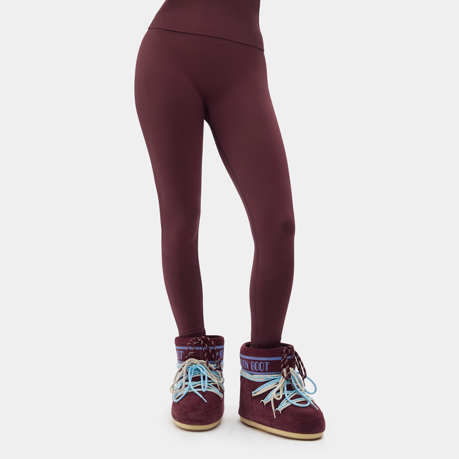 Maroon leggings with matching boots on a white background