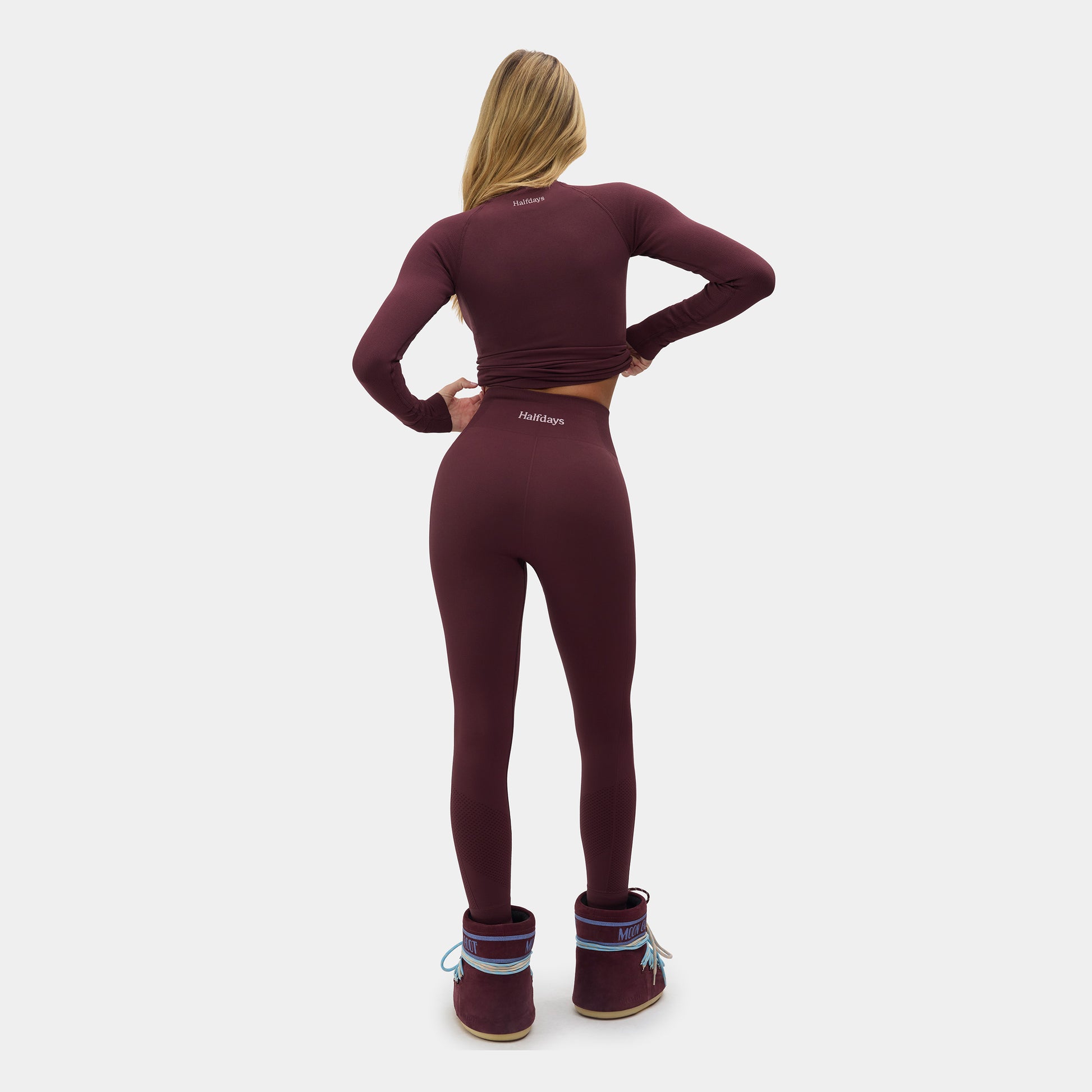 Person wearing a maroon athletic outfit with 'Halfdays' branding on a white background