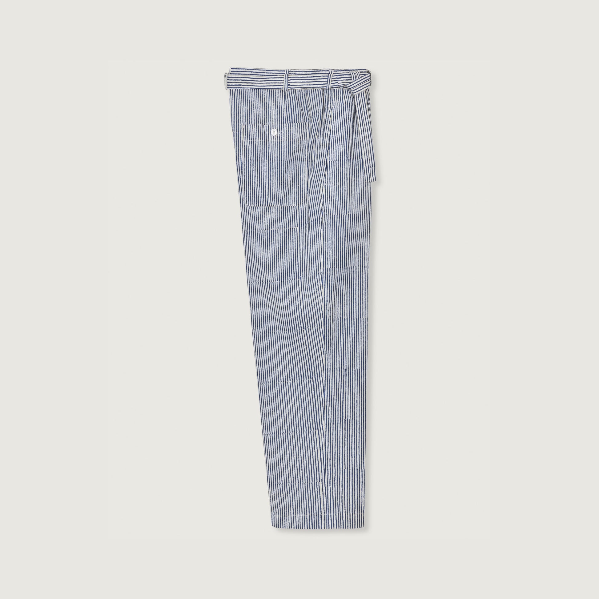 The Theo Trouser by Jan Machenhauer, featuring block print navy stripes and a matching belt, is neatly folded on a white background.