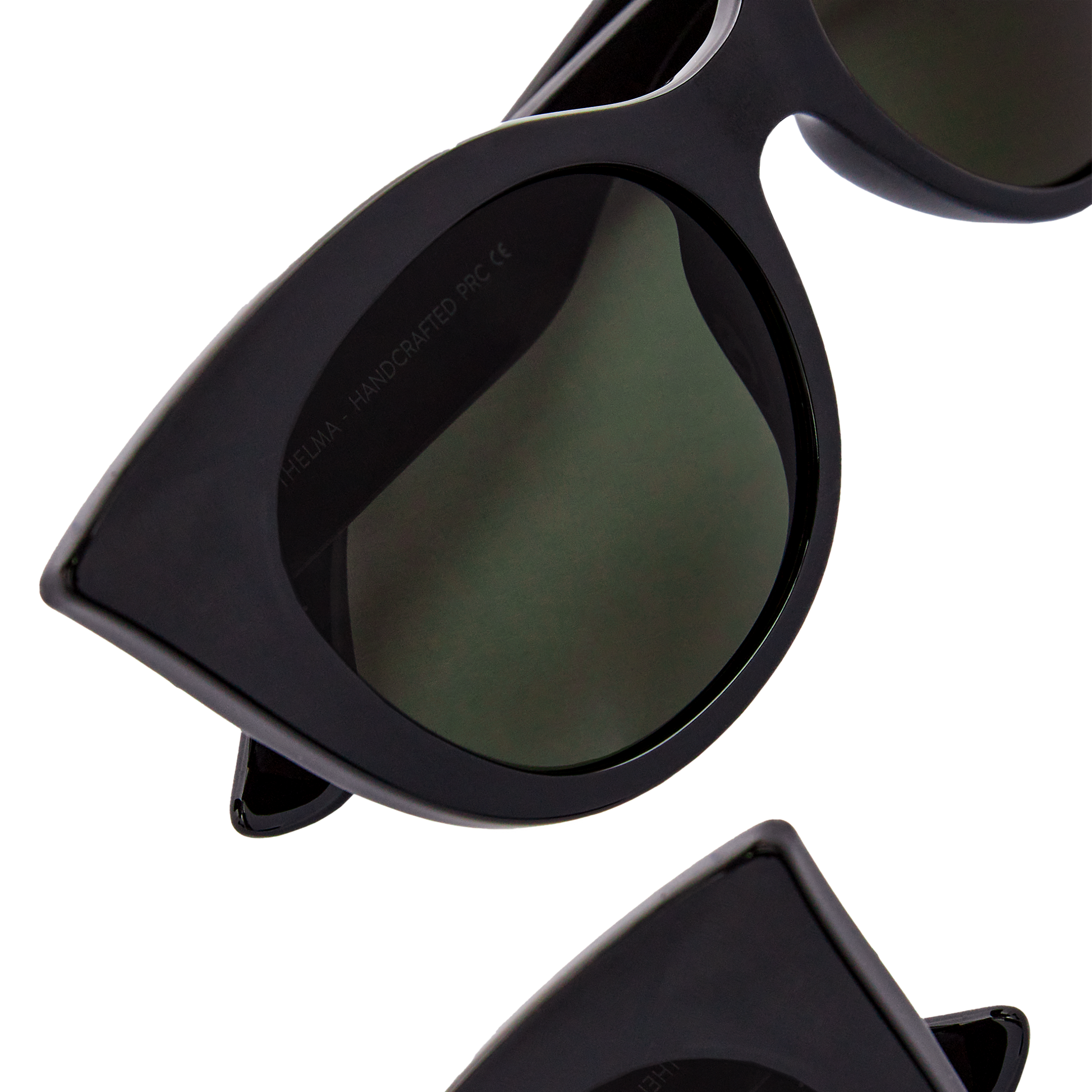 Close-up of Messyweekend Thelma cat-eye sunglasses in Black/Green with dark UV400 lenses, partially cropped at the bottom against a black background.