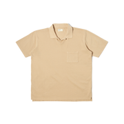 The Universal Works Vacation Polo in Sand is a short-sleeve collared shirt with a single chest pocket, shown laid flat on a white background.