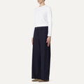 A person wearing a white cotton poplin long-sleeve shirt and Labo Art's Panta Diana Pant, Clara stands against a plain background.