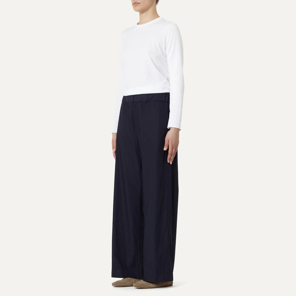 A person wearing a white cotton poplin long-sleeve shirt and Labo Art's Panta Diana Pant, Clara stands against a plain background.