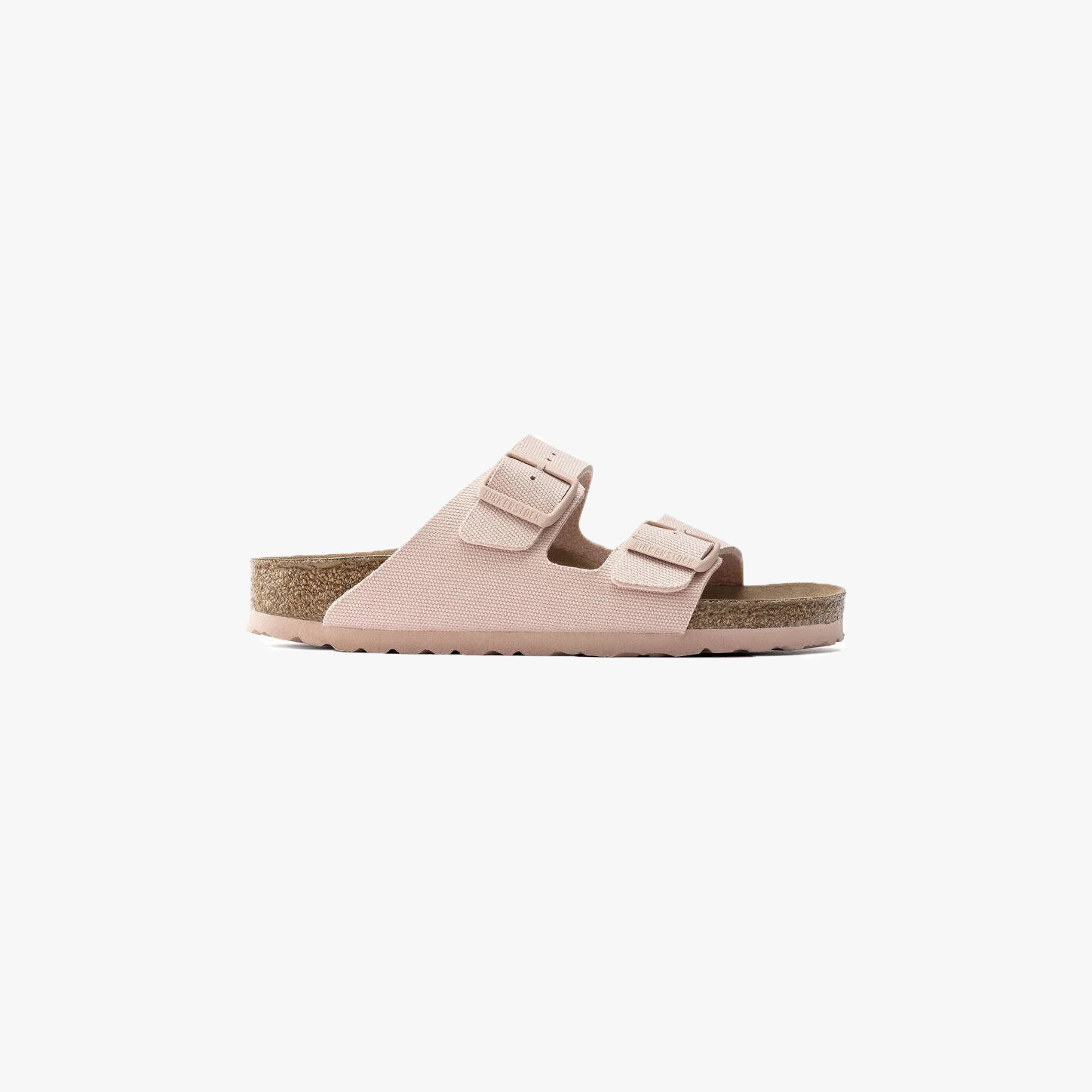The Birkenstock Arizona Vegan in Canvas Soft Pink (W) is a light pink unisex sandal with two adjustable buckle straps and a cork footbed, shown in profile on a white background. Consult the Birkenstock size chart for the perfect fit.