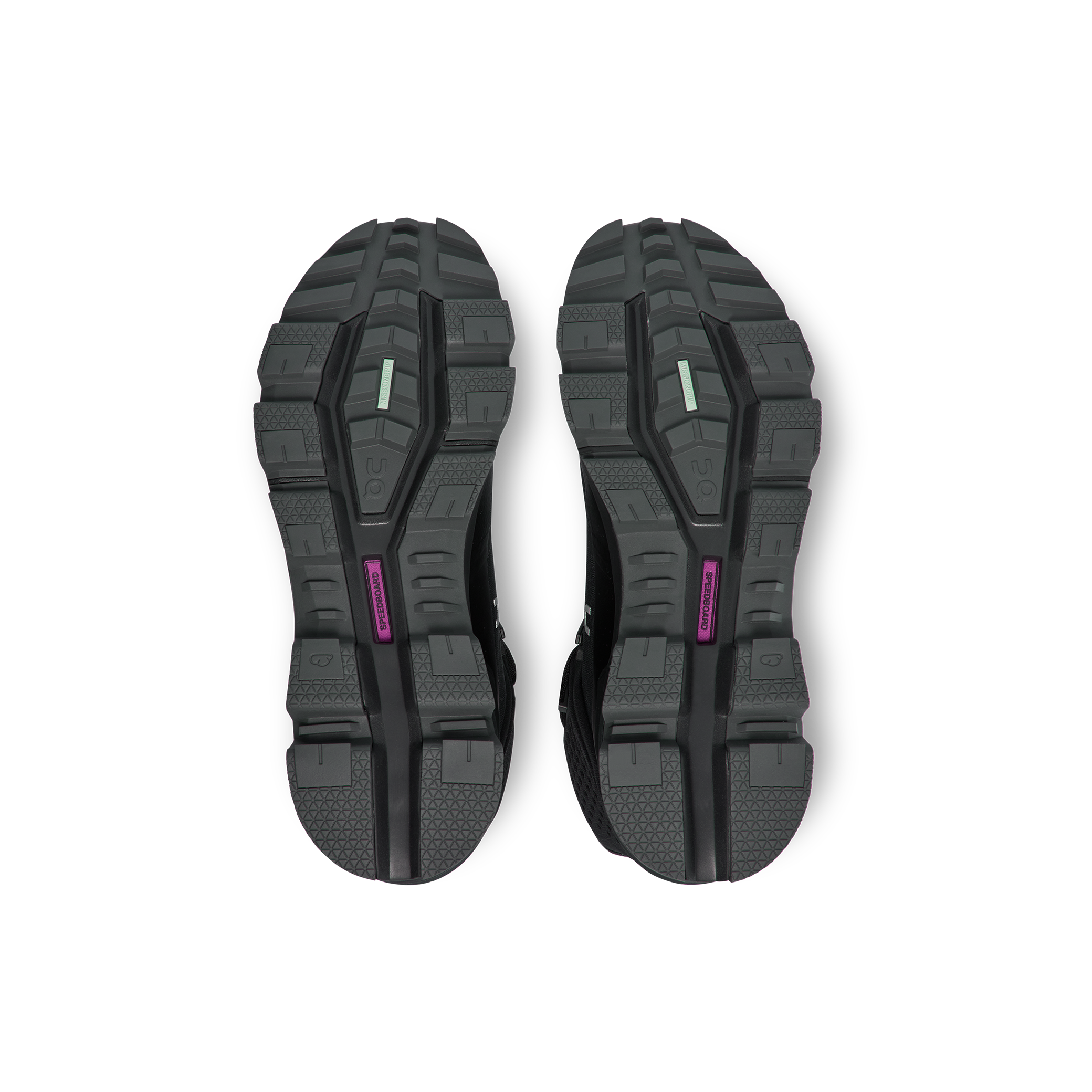 The image displays the black treaded soles of a pair of Women's Cloudrock 2 Waterproof athletic shoes by On Running, viewed from below, featuring colored accents in green and purple.