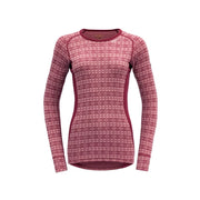 The Devold Alnes Woman Shirt in Fox Glove is a long-sleeved Merino wool top featuring a classic design with alternating rows of light pink diamond and circle shapes, ideal as an insulating baselayer.