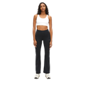 Facing forward, a woman wears Rohnisch's Flattering High Waist Pants and a white sports bra made from breathable fabric. Her look is completed with white sneakers against the plain background.