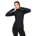A person dressed in the Rohnisch Free Motion Padded Jacket and black pants stands against a blank background, with the quilted woven polyester bringing subtle texture to their sleek attire.