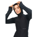 A person wearing the Free Motion Padded Jacket, a black zip-up athletic jacket with a hood from Rohnisch, crafted from recycled Thermo jersey, adjusts it while looking forward.