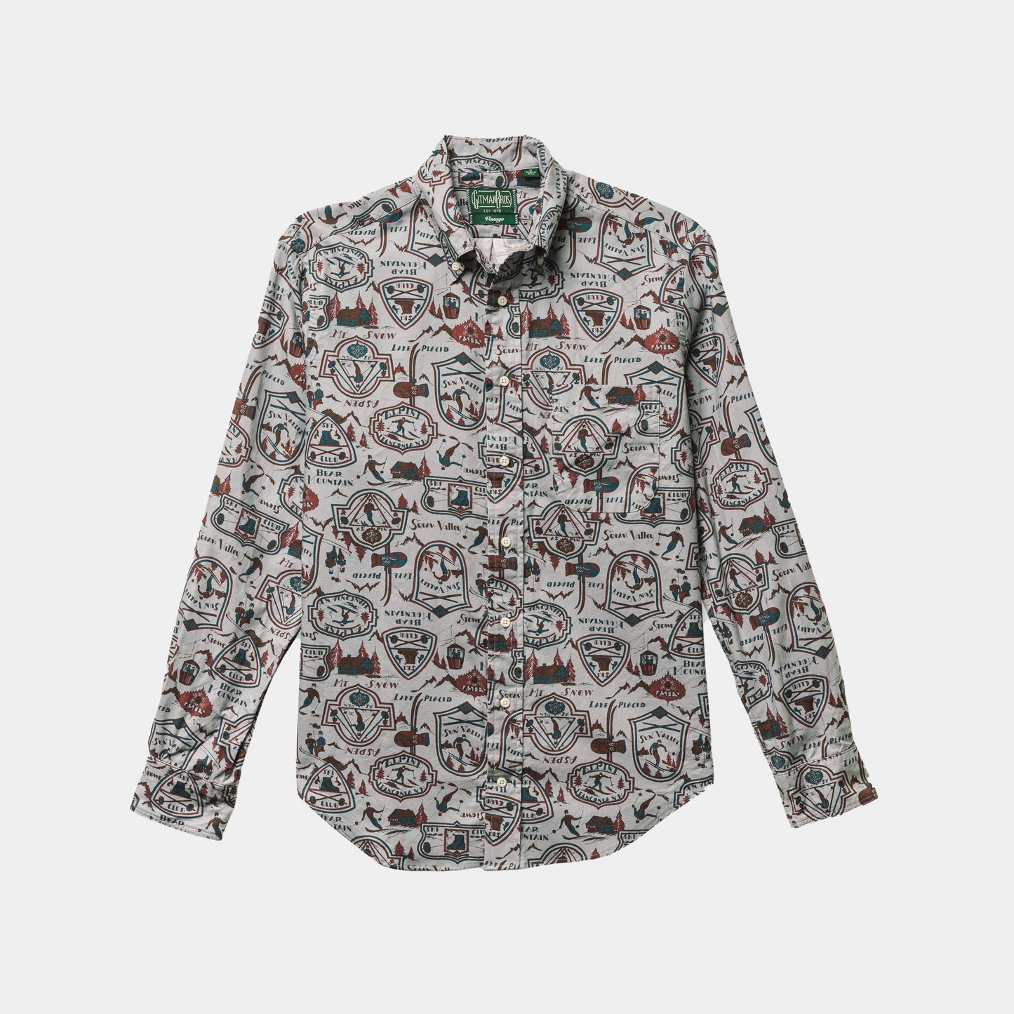 The Ski Club Print, Grey Pattern shirt by Gitman Vintage is a long-sleeve, button-up with a lively print of badges, shapes, and outdoor graphics on a light background.