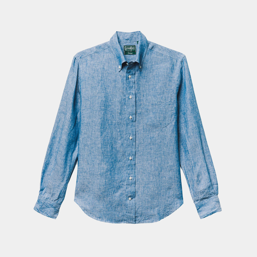 The Gitman Vintage Blue Chambray Linen Shirt features long sleeves, a button-up front, a collar, and a single chest pocket, shown laid flat on a white background.