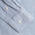 Close-up of the buttoned cuff on a Gitman Vintage Blue Stripe Linen Shirt with blue and white vertical stripes.