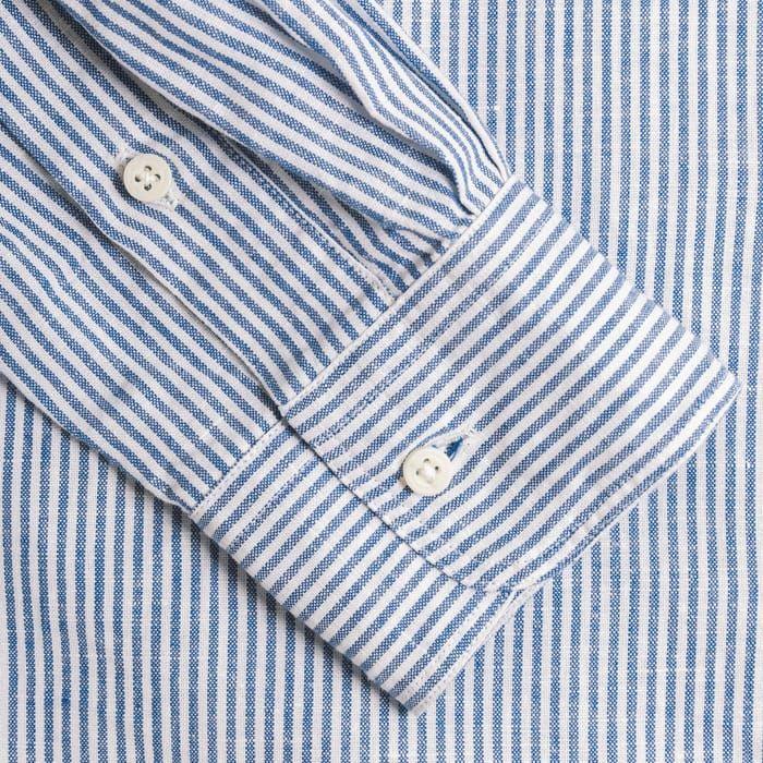 Close-up of the buttoned cuff on a Gitman Vintage Blue Stripe Linen Shirt with blue and white vertical stripes.