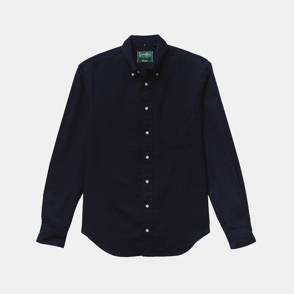 The Gitman Vintage Overdye Seersucker Shirt in Navy, a long-sleeve button-up with a collar and white buttons, is laid flat on a light background.