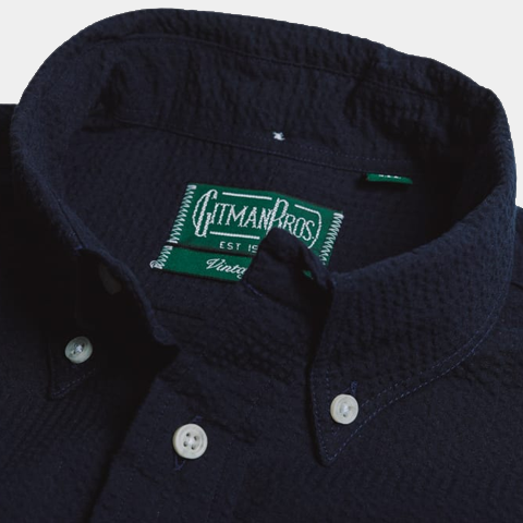 Close-up of a dark navy Overdye Seersucker Shirt collar with white buttons and a green Gitman Vintage label inside.