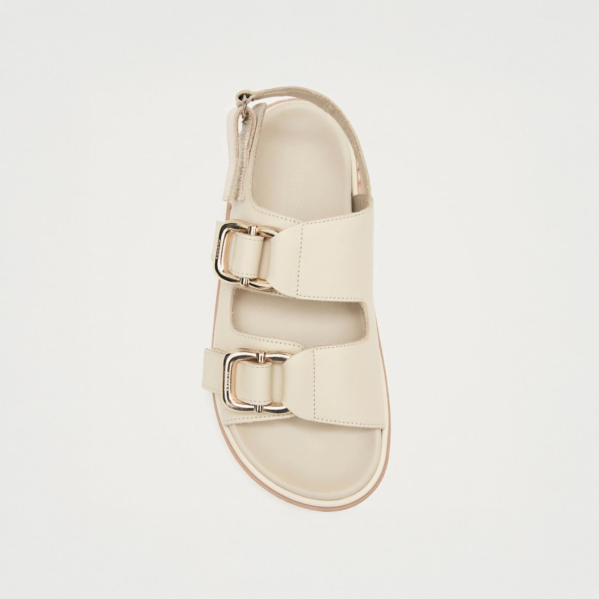 The Harper Sandal by Alohas in cream features two wide silver-buckle straps and a chunky sole, shown from above on a plain white background.