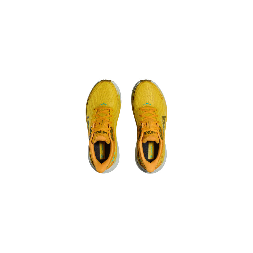 A pair of Hoka M Challenger ATR 7 shoes in Passionfruit/Golden Yellow, featuring orange laces, is shown from above on a white background and offers enhanced traction for all-terrain use.