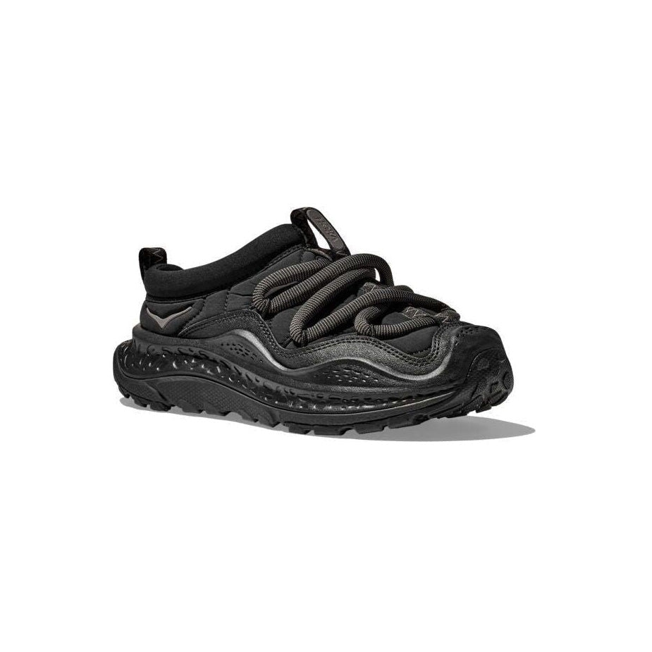 The Hoka U Ora Primo in black showcases a textured, insulated puff upper for easy slip-on comfort, complemented by thick twisted laces and a chunky sole, viewed from a slightly elevated angle.
