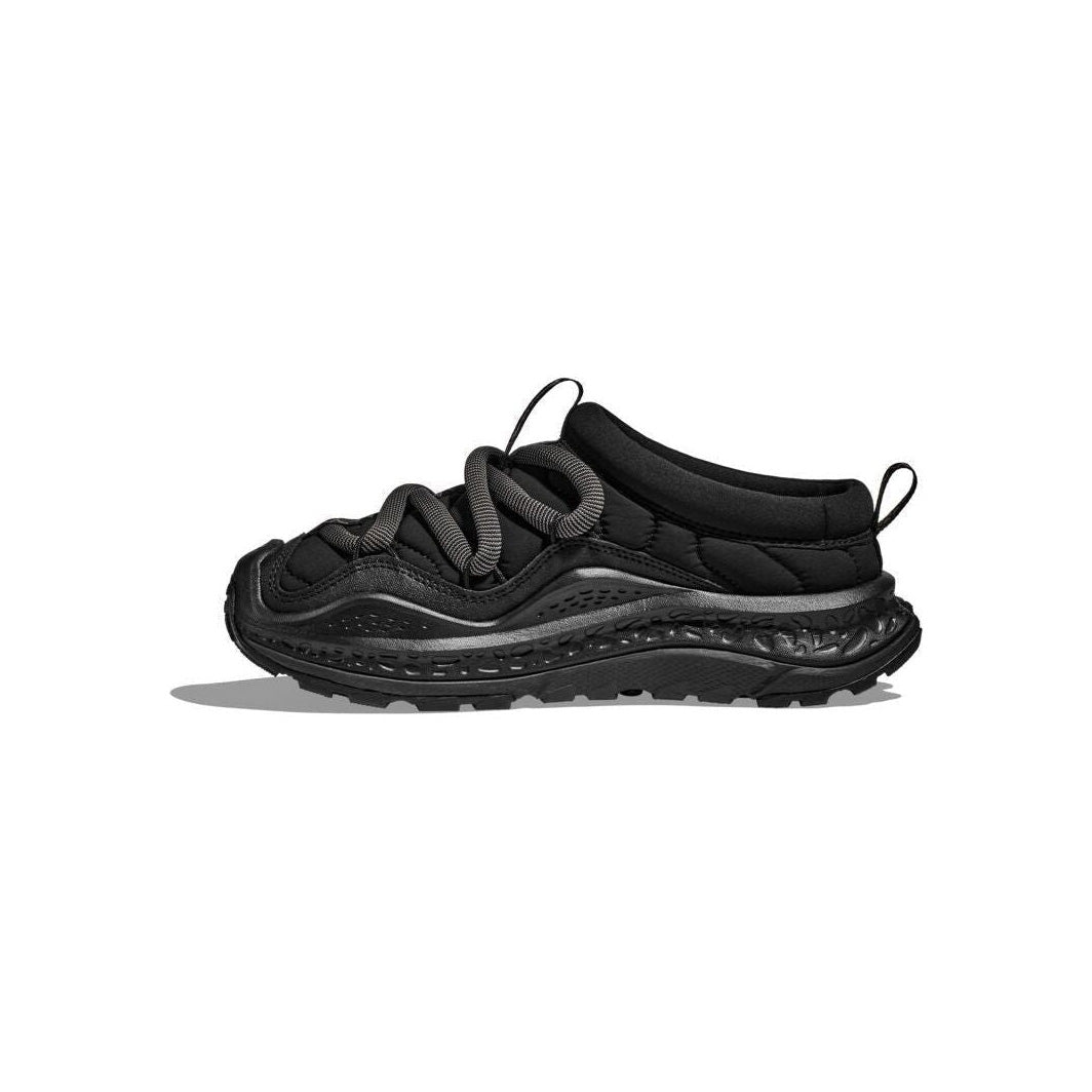 The sleek side view of the Hoka U Ora Primo in black showcases its slip-on comfort, featuring thick laces and a textured sole, set against a plain white background.