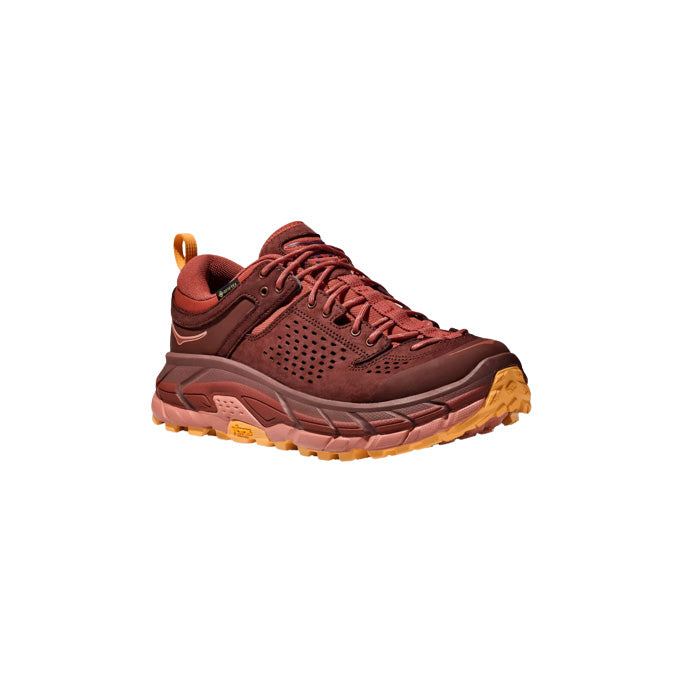 The Hoka U Tor Ultra Lo in Spice/Hot Sauce is a maroon and orange athletic shoe with a thick sole, lace-up design, side perforations for ventilation, and a heel loop for easy pulling.