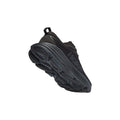 The W Bondi 8 shoe by Hoka in Black/Black features a thick sole with a unique tread pattern and "HOKA" branding. Its extended heel design boosts performance and showcases the sleek aesthetics of the shoe.