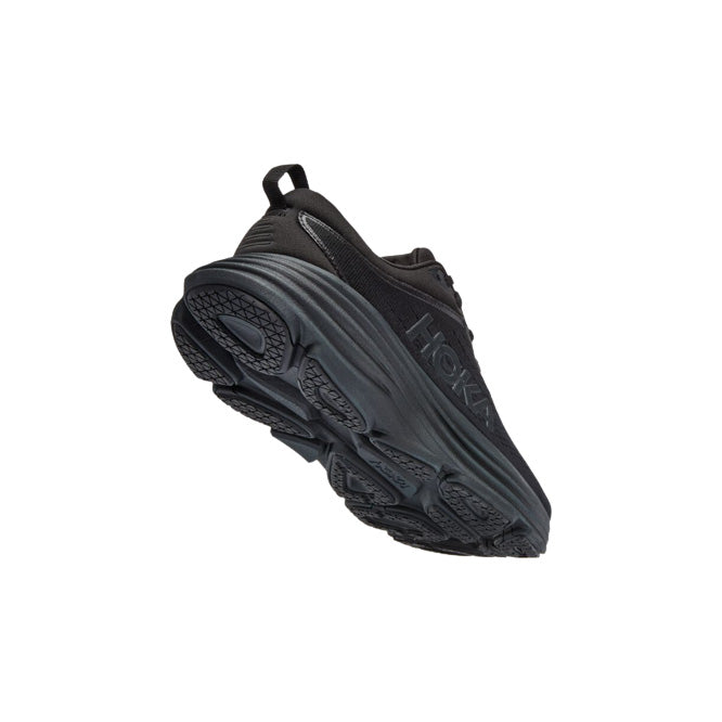 The W Bondi 8 shoe by Hoka in Black/Black features a thick sole with a unique tread pattern and "HOKA" branding. Its extended heel design boosts performance and showcases the sleek aesthetics of the shoe.