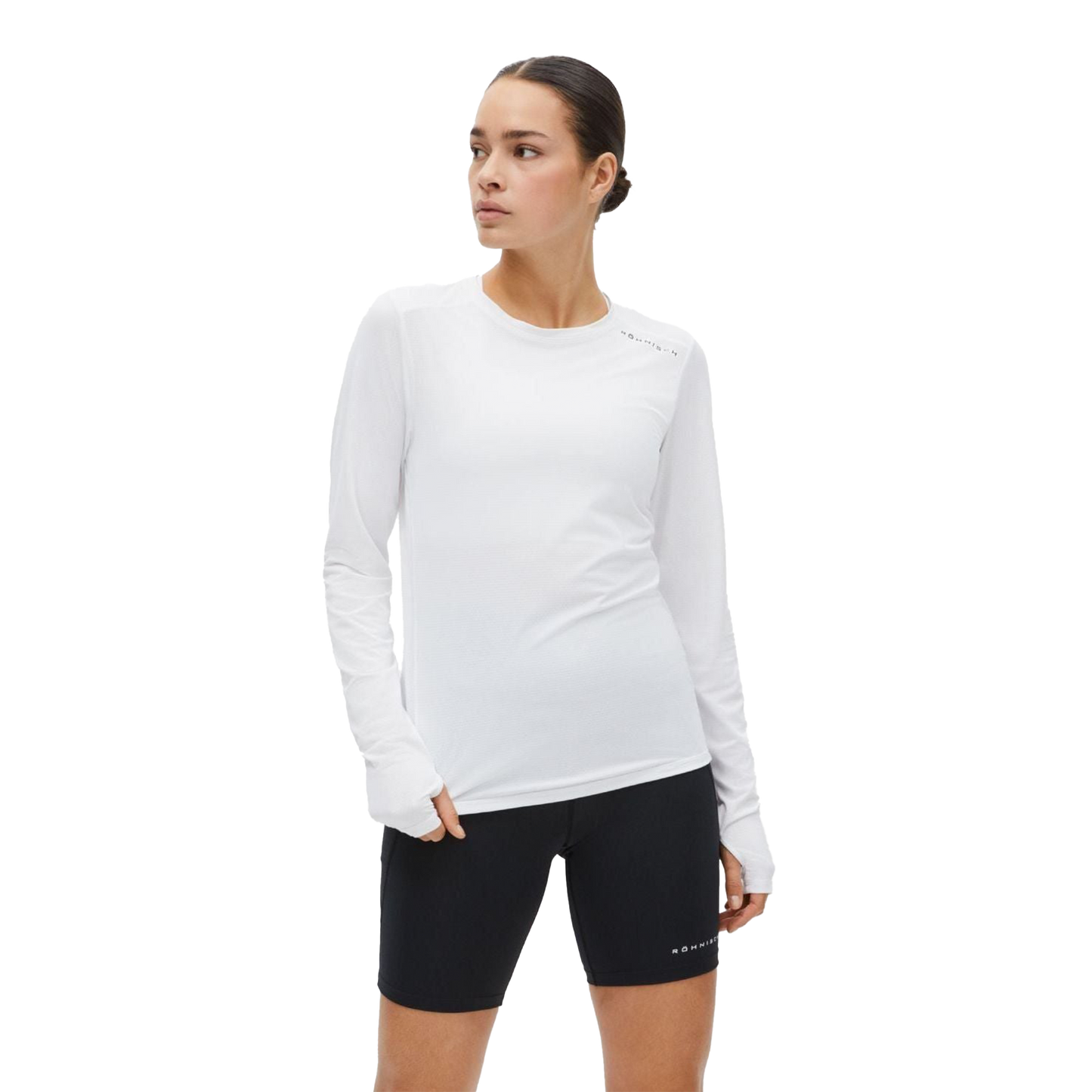 Wearing a Jacquard Long Sleeve Tee by Rohnisch in white, paired with black shorts made from recycled polyester, a person stands against a plain backdrop, gazing sideways.