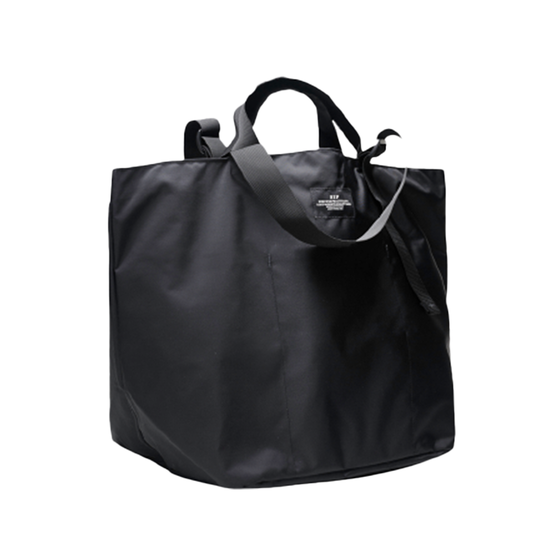 The Large Double Handle Tote by Bags in Progress is a black tote bag with short handles and a long adjustable strap, crafted from woven nylon.