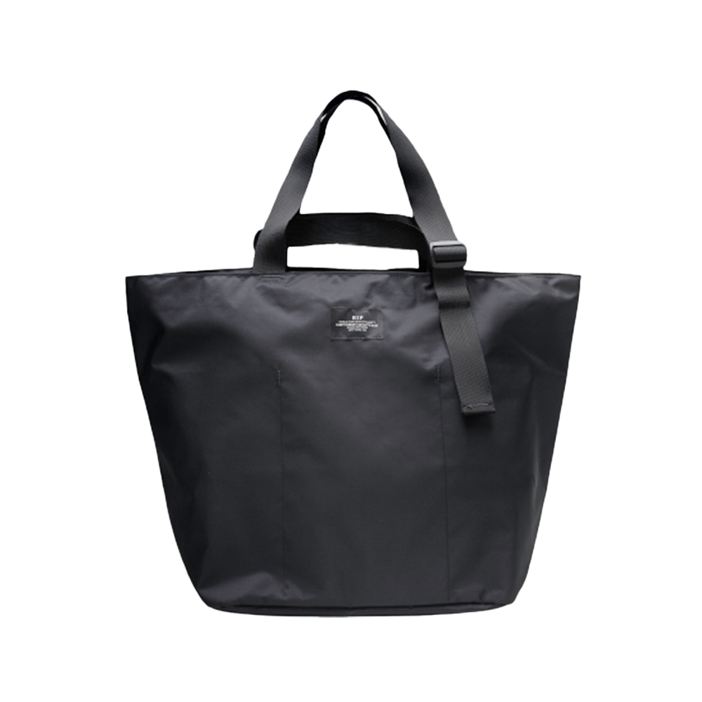 The Large Double Handle Tote by Bags in Progress is a black woven nylon bag with double handles and a detachable shoulder strap, set against a white background.