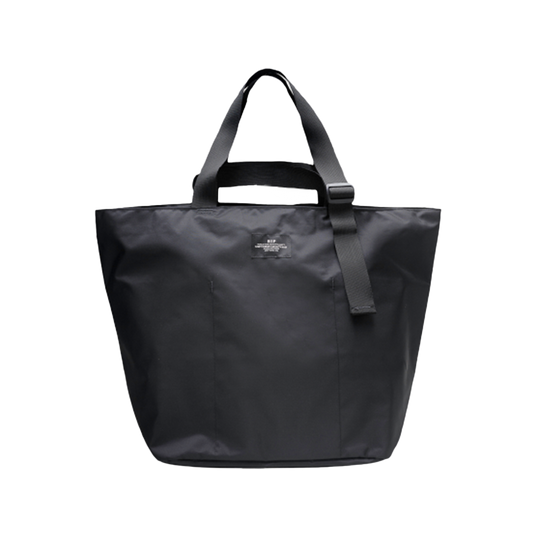 The Large Double Handle Tote by Bags in Progress is a black woven nylon bag with double handles and a detachable shoulder strap, set against a white background.