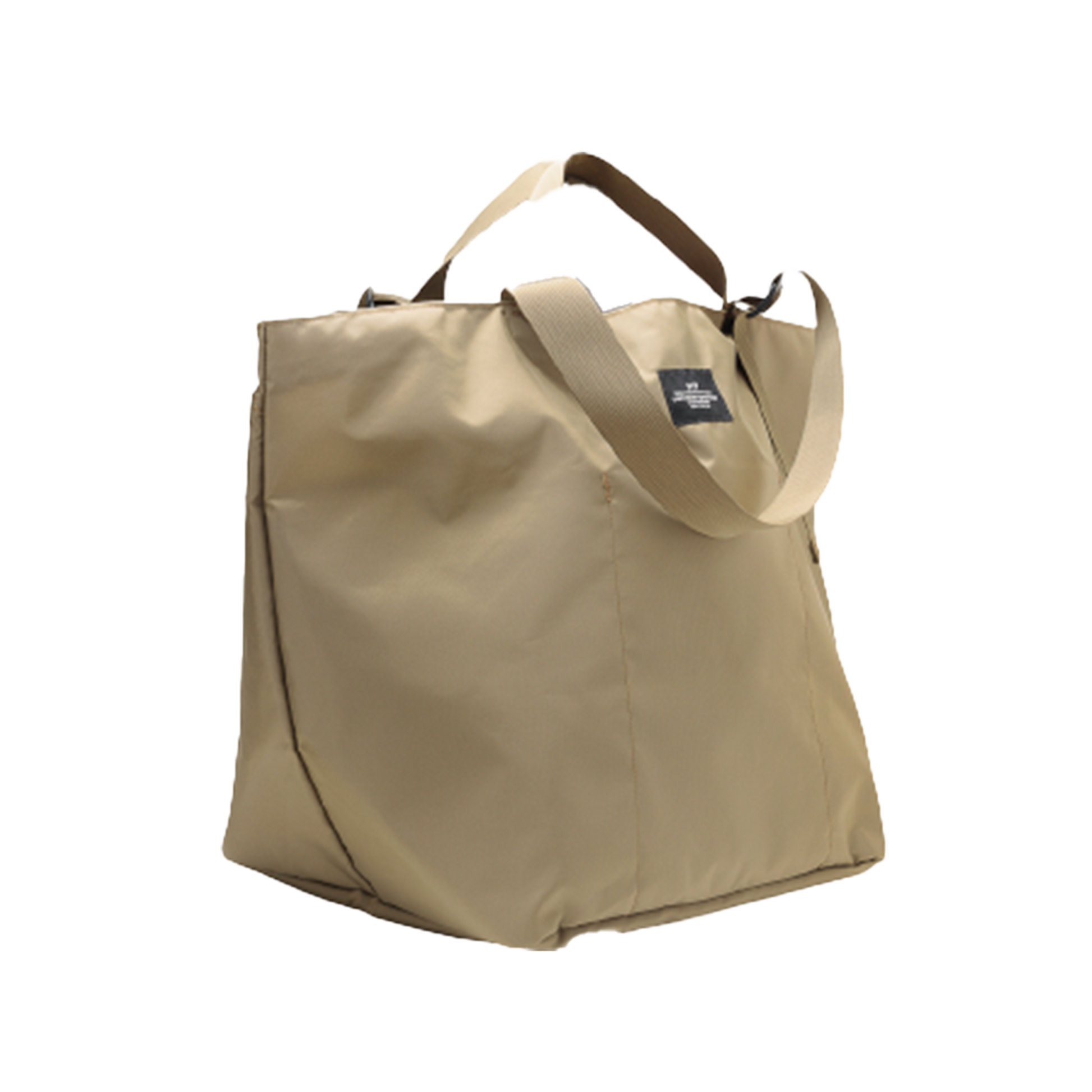 The Large Double Handle Tote by Bags in Progress is a beige tote crafted from woven nylon, featuring a black label, double handles, and an adjustable shoulder strap.