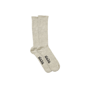 The Aiayu Llama Socks are a beige, unisex pair made from thermoregulating llama wool, featuring black text on the soles over a black background.