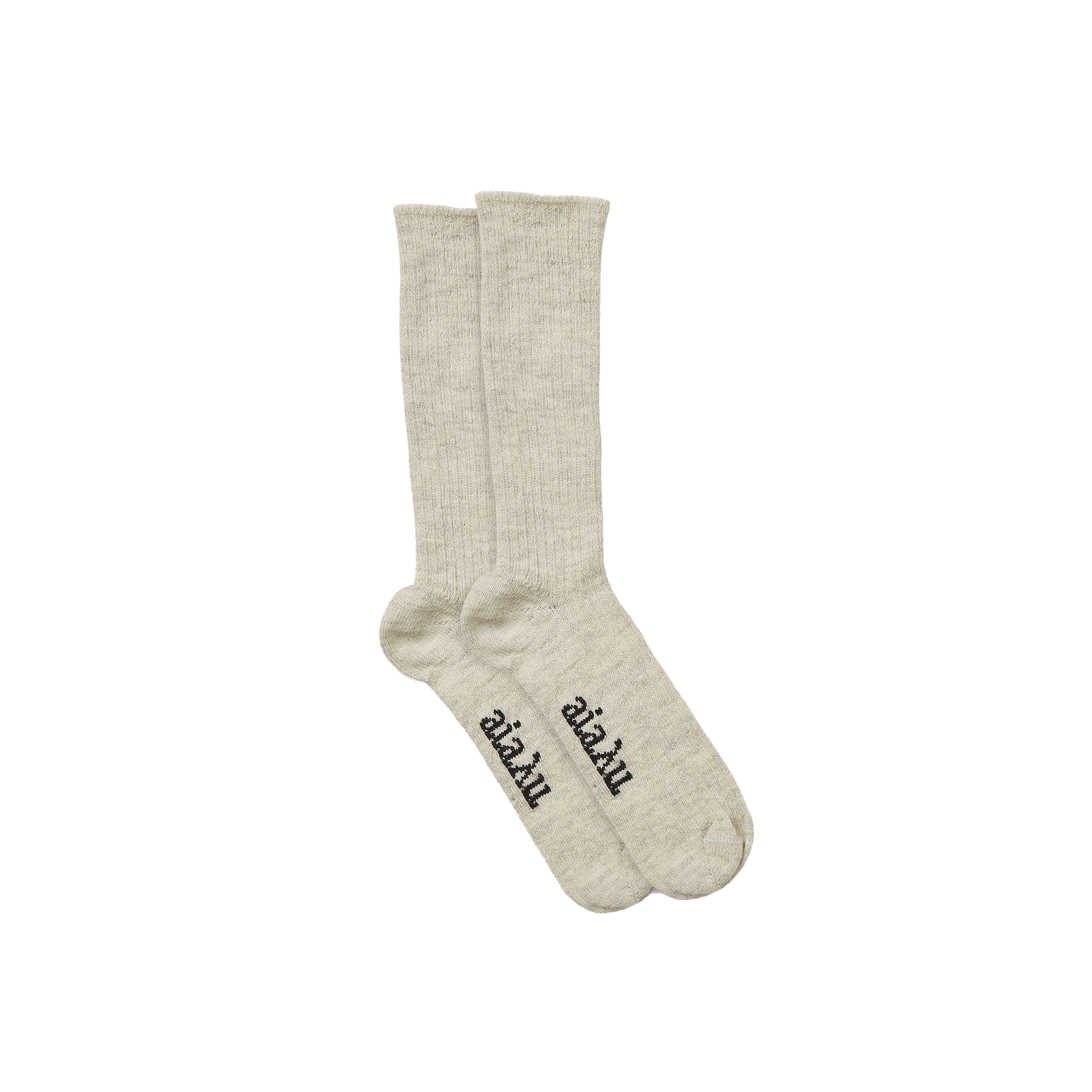 The Aiayu Llama Socks are a beige, unisex pair made from thermoregulating llama wool, featuring black text on the soles over a black background.