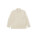 A Universal Works LS Utility Shirt in beige, made from 100% cotton, showcases long sleeves and button flap chest pockets while laid flat against a black background.