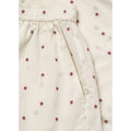 Close-up of cream-colored fabric with small red flower patterns, gathered at the top with an elastic waistband, resembling Aiayu's Lulu Shorts Flore in Mix Creme made from regenerative cotton.