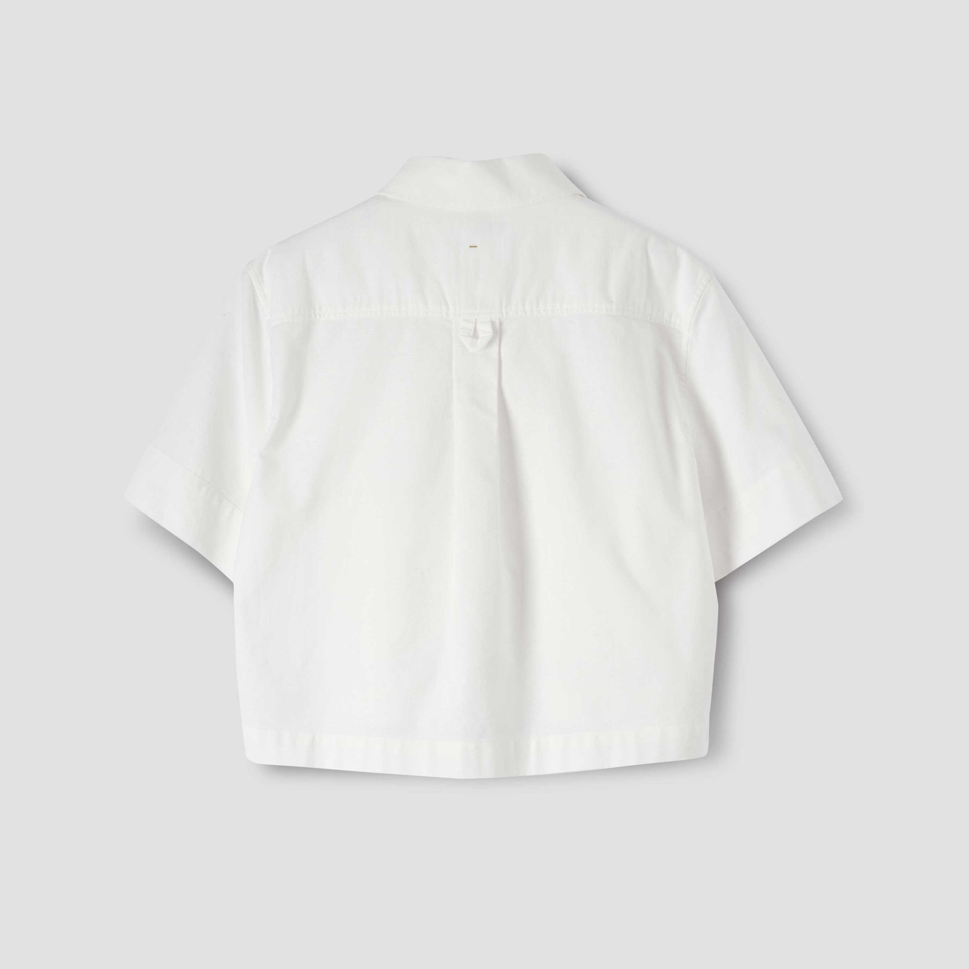 Back view of the Margaret Howell W Cropped Uniform Shirt with short sleeves and Japanese panama weave, laid flat on a light gray background.