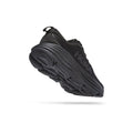 The Hoka W Bondi 9 in Black/Black is shown angled on a white background, featuring thicker, softer foams, an extended heel geometry, a textured tread pattern, and the side logo.