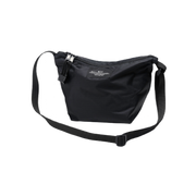 The Micro Tote by Bags in Progress is a lightweight black shoulder bag made from nylon, featuring a zipper closure and an adjustable strap, beautifully photographed against a white background.