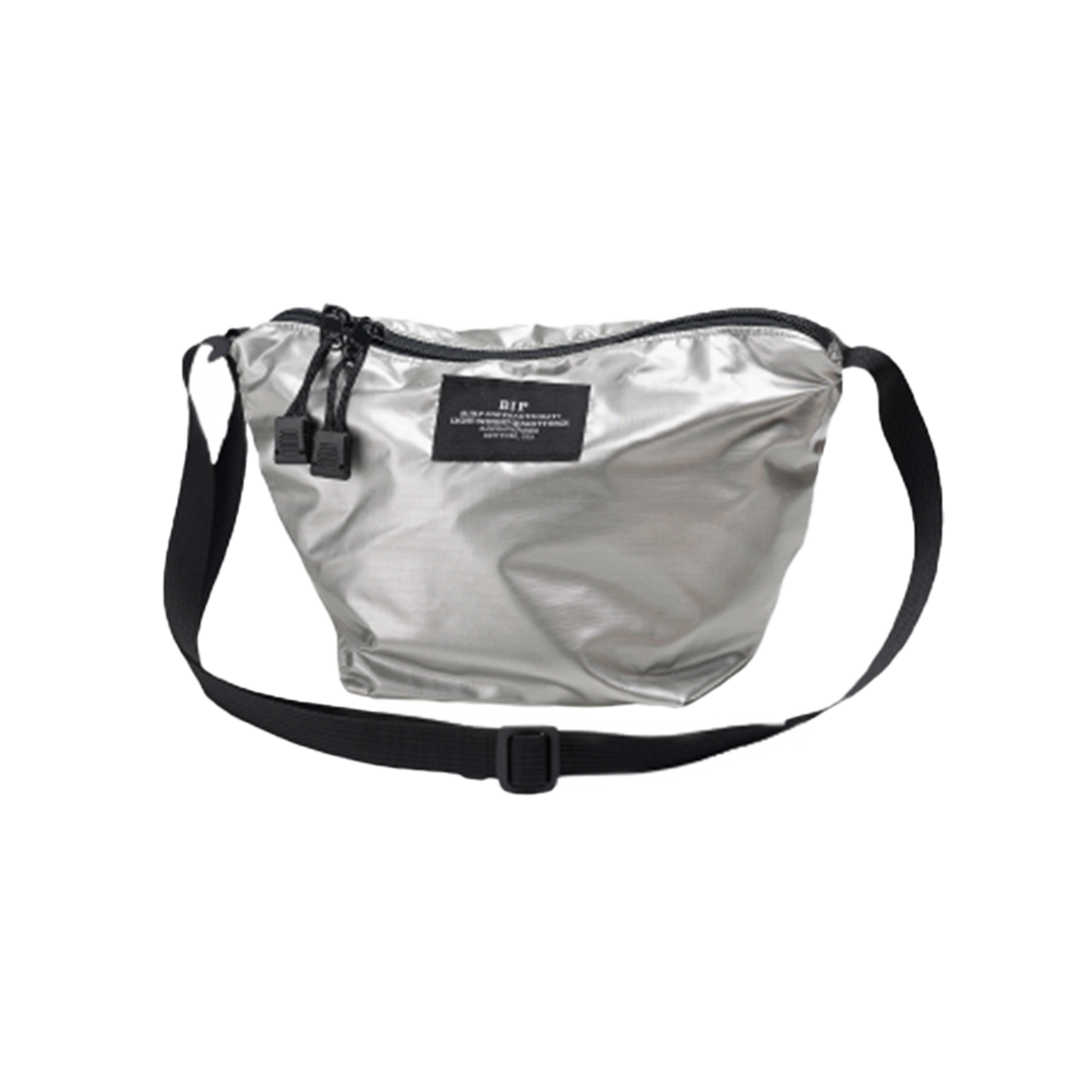The Micro Tote by Bags in Progress is a silver nylon crossbody bag featuring adjustable black straps and a sleek black label on the front, combining style with the convenience of a lightweight accessory.