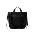 The Bags in Progress New York Tote Medium is a black cotton canvas bag made in Japan, featuring two short handles and a long adjustable shoulder strap, displayed against a white background.
