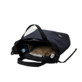 The Bags in Progress New York Tote Medium, an open black cotton canvas bag with an adjustable shoulder strap, displays a water bottle, folder, and notebook in its compartments against a plain background.