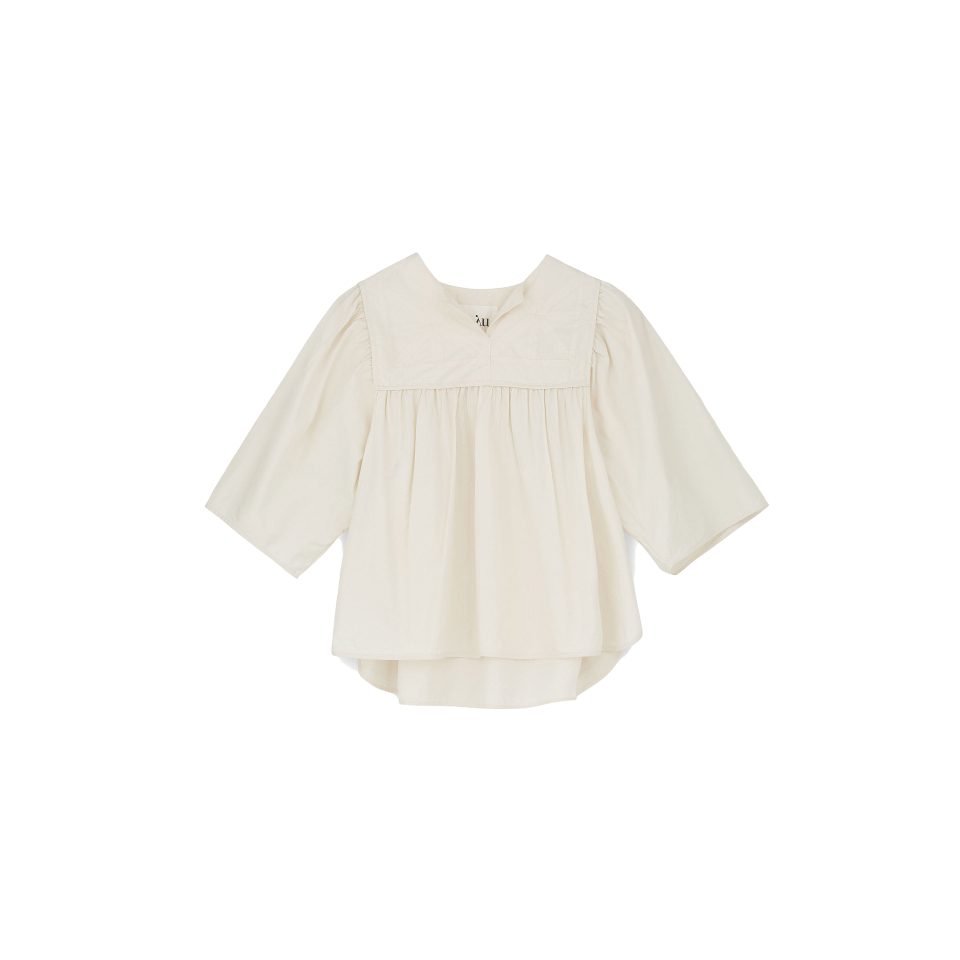 The Nomi Blouse by Aiayu features a cream color with long sleeves, a pleated front, and a wide collar, all crafted from sustainable materials. This 70s-inspired design is elegantly captured against a plain black background.