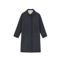 The Noor Coat Oil by Aiayu is a long, dark classic coat made from wax-coated organic cotton, featuring a classic collar and two front pockets, displayed on a plain background.