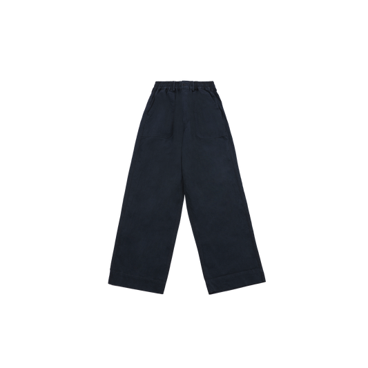 The One Tuck Wide Fatigue Pant by Kappy is a unisex, one size fits most design in navy blue, featuring wide legs, an elastic waistband, and large front pockets. It's showcased against a plain background.