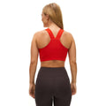 A woman, with her back to the camera, wears a Rohnisch Kay Sports Bra made from recycled polyester in red and black leggings. Her simple fitness attire contrasts against the plain white background, suggesting moisture-wicking comfort for workouts.