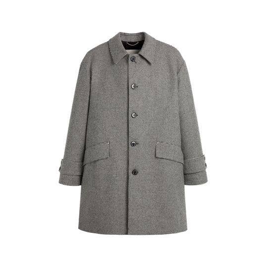 The W Humbie Chester Cocoon by Mackintosh is a 100% wool, oversized black-and-white houndstooth coat made in the UK. It features buttons, two pockets, and long sleeves and is elegantly displayed on a black background.